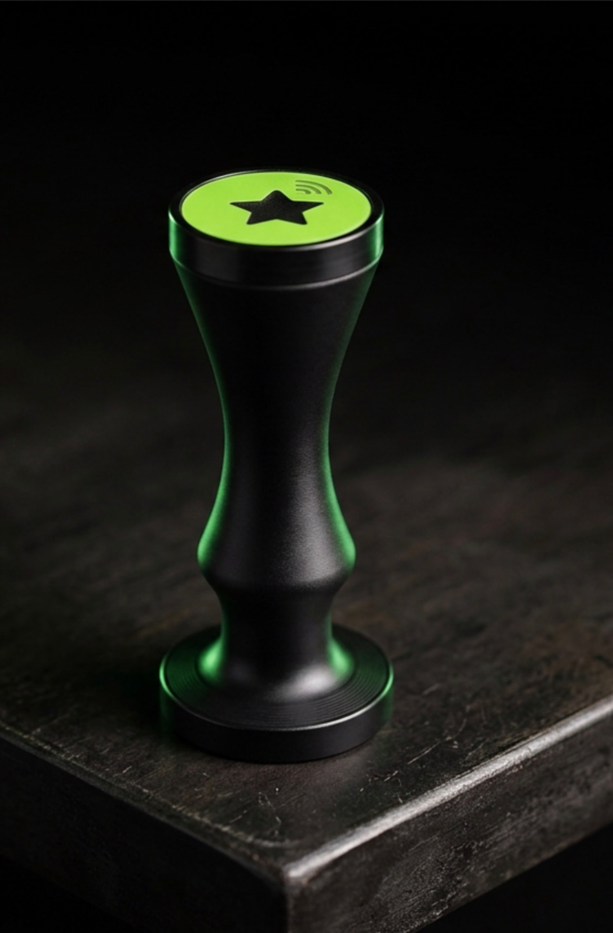 The LoyaltyTap NFC stamp: a black device with a green top and star symbol used by staff to add a loyalty stamp to a customer's phone